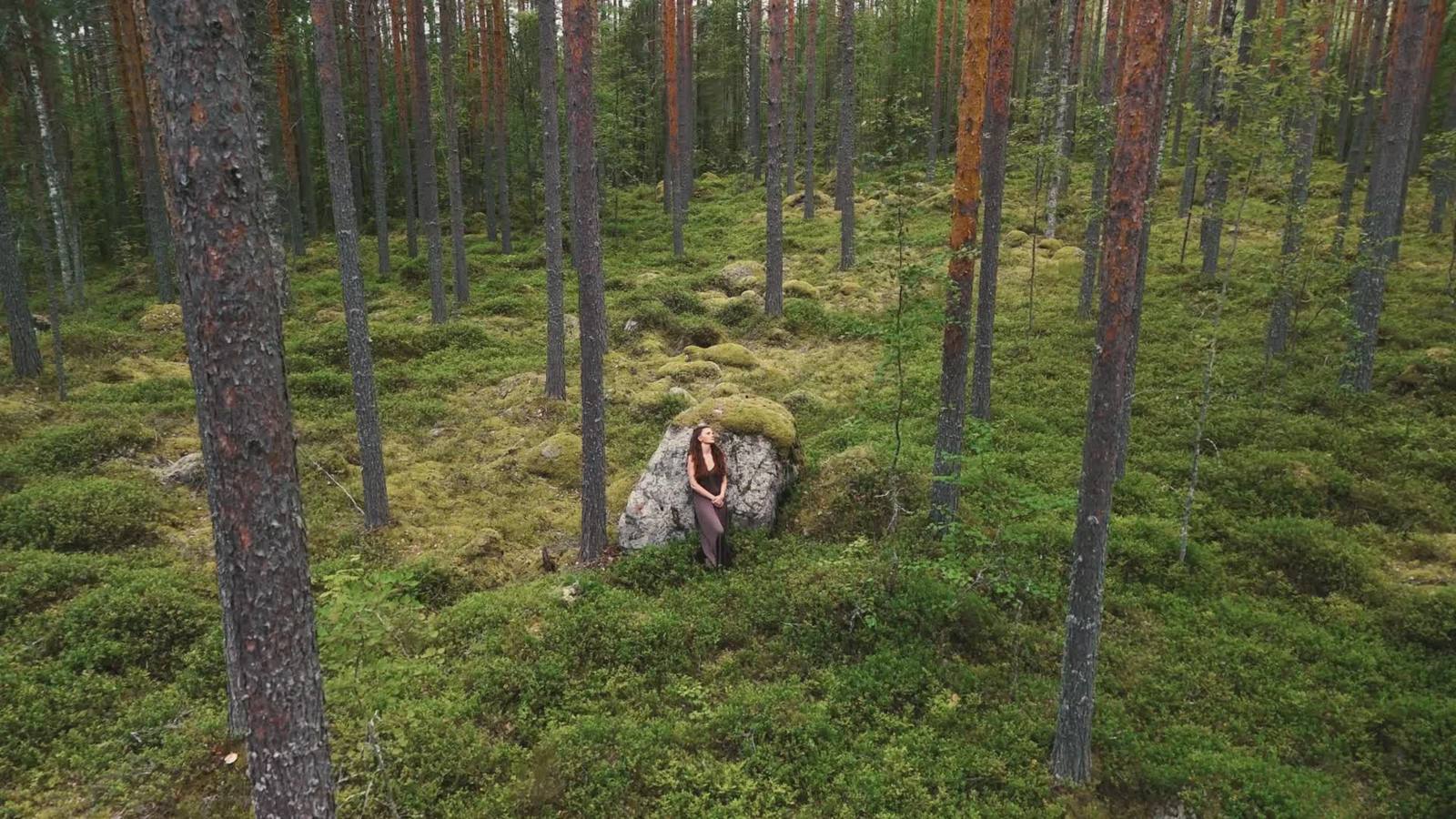Selina an einem moosbewachsenen Felsen in einem Kiefernwald