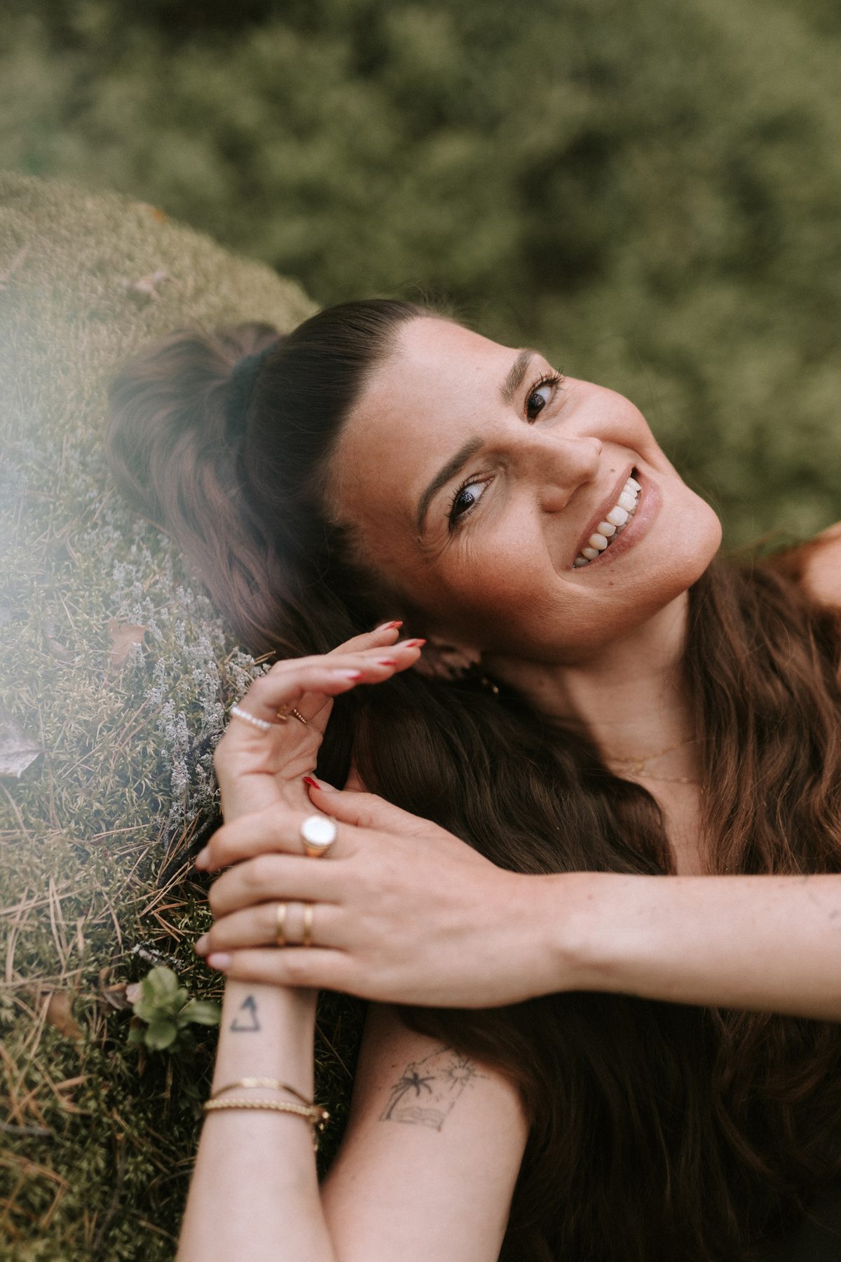 Selina liegt lachend im Moos